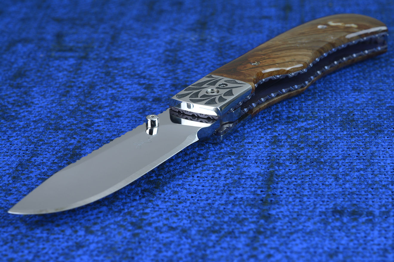 "Sadr" linerlock folding knife, handle detail showing anodized and fileworked titanium liners and front bolster and pivot detail "Sadr" linerlock folding knife, handle detail showing anodized and fileworked titanium liners and front bolster and pivot detail
