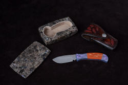 "Elysium" ensemble including fine handmade liner lock folding knife with gemstone handle and titanium bolsters and liners, hand-carved sheath inlaid with red rayskin, knife sarcophagus in polished anorthosite gemstone "Elysium" ensemble including fine handmade liner lock folding knife with gemstone handle and titanium bolsters and liners, hand-carved sheath inlaid with red rayskin, knife sarcophagus in polished anorthosite gemstone