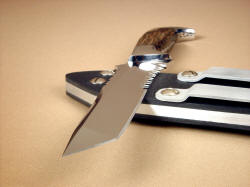 "PJLT" point detail. Grind and point of tanto blade offers tough and durable edges, two points for applying pressure, two inches of rip teeth serrations for tough cutting chores "PJLT" point detail. Grind and point of tanto blade offers tough and durable edges, two points for applying pressure, two inches of rip teeth serrations for tough cutting chores
